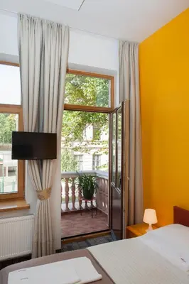 a bedroom with a bed and a window with a balcony at Moja Accommodation in Kaunas