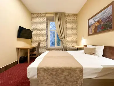 a hotel room with a large bed and a desk at New Town Home 2 in Vilnius