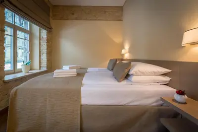 a bedroom with a large bed with white sheets and pillows at New Town Home 2 in Vilnius
