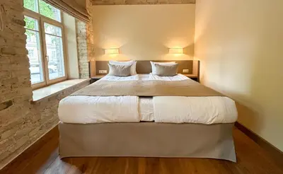a bedroom with a large bed with white sheets and pillows at New Town Home 2 in Vilnius