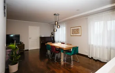 a dining room with a table and green chairs at Garden Cottage in Šiauliai
