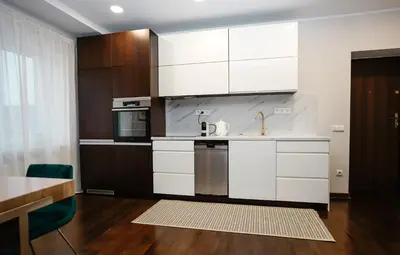 a kitchen with white cabinets and a sink at Garden Cottage in Šiauliai