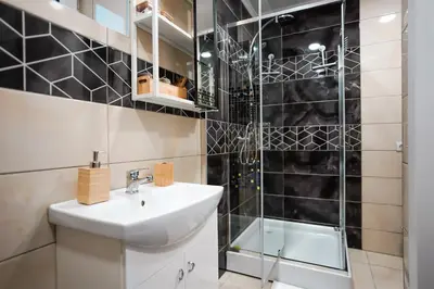 a bathroom with a sink and a shower at Garden Cottage in Šiauliai