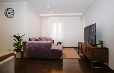 a living room with a couch and a tv at Garden Cottage in Šiauliai