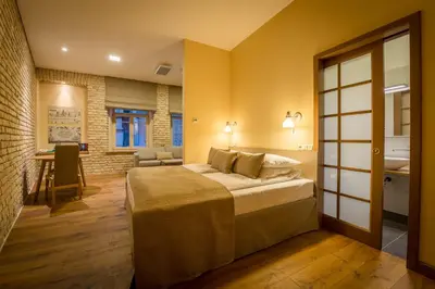a bedroom with a bed and a living room at New Town Home 3 in Vilnius