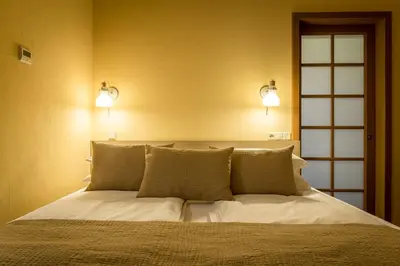 a bedroom with a bed with two lights on it at New Town Home 3 in Vilnius