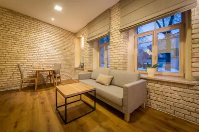 a living room with a couch and a brick wall at New Town Home 3 in Vilnius
