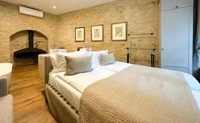 a large bed in a room with a brick wall at New Town Home in Vilnius
