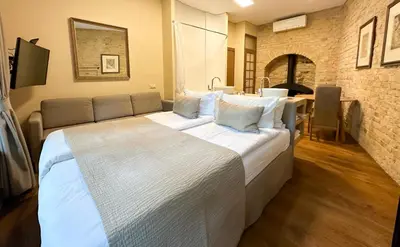 a large white bed in a room with a table at New Town Home in Vilnius