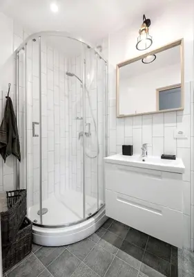 a white bathroom with a shower and a sink at Sunshine apartamentai in Alytus