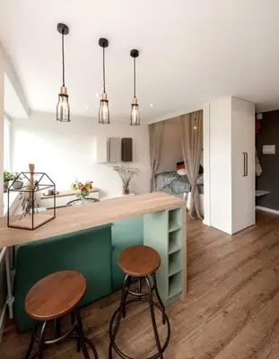 a kitchen with two stools and a counter in a room at Sunshine apartamentai in Alytus