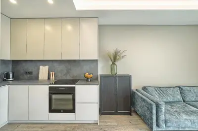 a kitchen with white cabinets and a blue couch at Amazing central apartments x free parking x SELF CHECK IN 24x7 in Vilnius