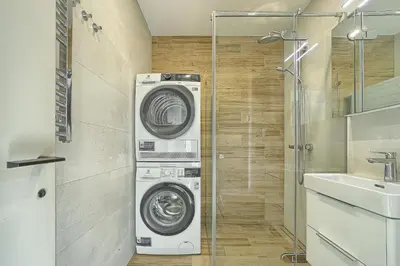 a washer and dryer in a bathroom with a sink at Amazing central apartments x free parking x SELF CHECK IN 24x7 in Vilnius