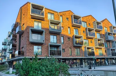 a large brick building with balconies on a street at Amazing central apartments x free parking x SELF CHECK IN 24x7 in Vilnius