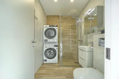 a bathroom with a washing machine and a washer and dryer at Amazing central apartments x free parking x SELF CHECK IN 24x7 in Vilnius