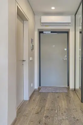 an empty hallway with a large door and wooden floors at Amazing central apartments x free parking x SELF CHECK IN 24x7 in Vilnius