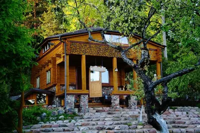 a log cabin in the woods with a stone path at Pasakų namelis dviems su vaizdu į ežerą in Esperanza