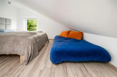 a bed with a blue blanket in a bedroom at Vila Valentino in Klepšiai