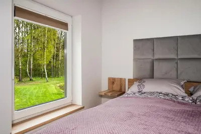 a bedroom with a bed and a large window at Vila Valentino in Klepšiai