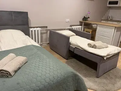 two twin beds in a room with a kitchen at Kakava House in Nemėžis