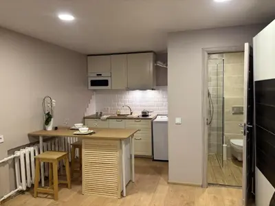 a small kitchen with a table and a sink at Kakava House in Nemėžis
