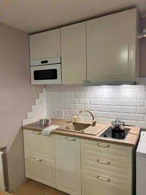a kitchen with white cabinets and a sink at Kakava House in Nemėžis