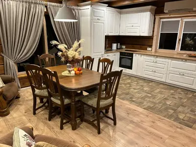 a kitchen with a wooden table with chairs and a tableablish at Užmiesčio trobelė in Mackėnai