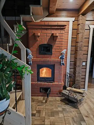 a brick fireplace in the middle of a room at Užmiesčio trobelė in Mackėnai