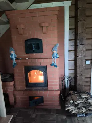 a brick fireplace with two figurines on top of it at Užmiesčio trobelė in Mackėnai