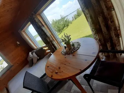 a wooden table in a room with a large window at Marių Kalvos in Palėvenėlė