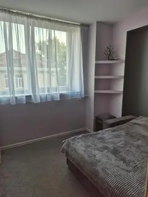 a bedroom with a bed and a window at four room's apartments in Vilnius