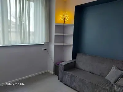 a living room with a couch and a window at four room's apartments in Vilnius