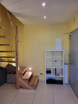 a room with a staircase and a shelf with wine bottles at four room's apartments in Vilnius