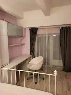 a room with a white chair in a room at four room's apartments in Vilnius