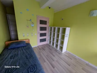 a bedroom with a bed in a room with green walls at four room's apartments in Vilnius