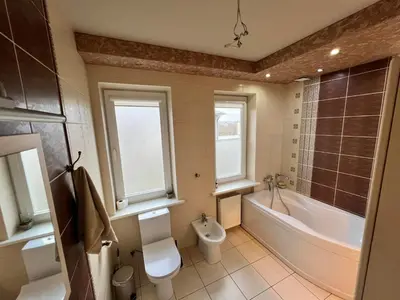a bathroom with a tub and a toilet and a sink at Azimut Guest House Quiet Getaway Garden Sauna in Šiauliai