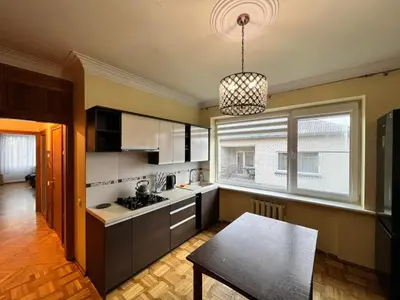 a kitchen with a table and aendant light at Azimut Guest House Quiet Getaway Garden Sauna in Šiauliai