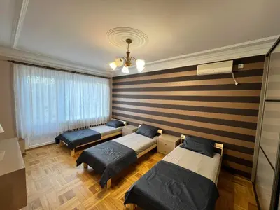 a room with three beds and a wall at Azimut Guest House Quiet Getaway Garden Sauna in Šiauliai