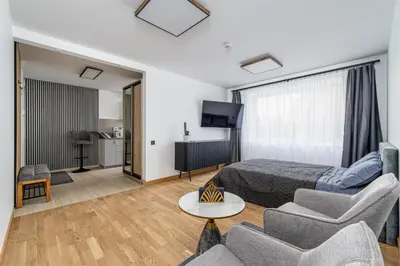 a room with a bed and a couch and a tv at Rasytes 10 in Kaunas