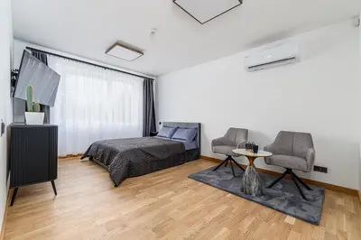 a bedroom with a bed and two chairs and a table at Rasytes 10 in Kaunas