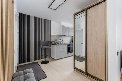 a living room with a sliding glass door leading to a kitchen at Rasytes 10 in Kaunas