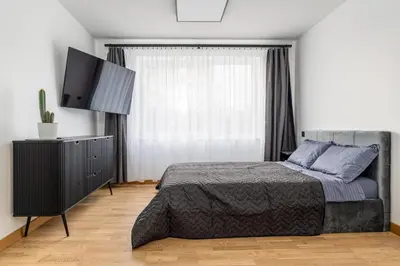 a bedroom with a bed and a flat screen tv at Rasytes 10 in Kaunas