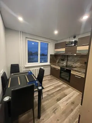 a kitchen with a table and chairs in a room at Jaukus butas Jonavoje in Jonava