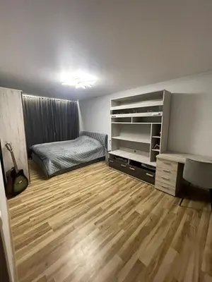 a room with a bedroom with a bed and a wooden floor at Jaukus butas Jonavoje in Jonava