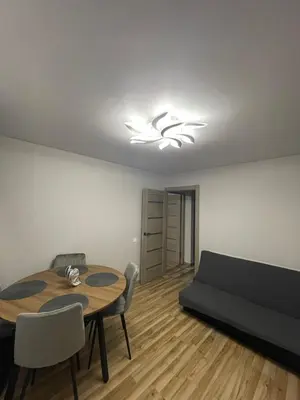 a living room with a table and a couch at Jaukus butas Jonavoje in Jonava