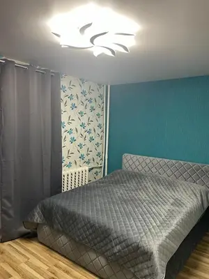 a bedroom with a bed and a chandelier at Jaukus butas Jonavoje in Jonava