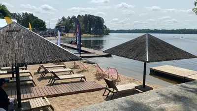 a beach with chairs and tables and umbrellas at Aquaspot Kaunas in Kaunas