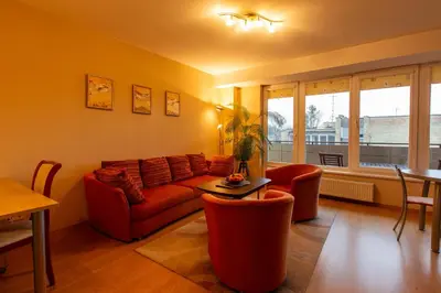 a living room with a red couch and a table at DJ home in Druskininkai