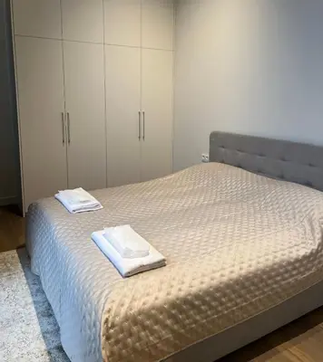 a bedroom with a bed with two towels on it at Maironio apartamentai in Kaunas