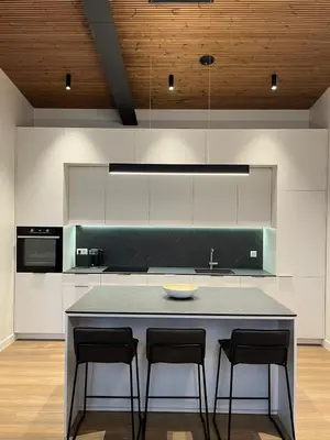 a kitchen with a counter with two chairs and a island at Maironio apartamentai in Kaunas